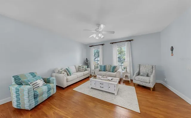 a living room with furniture wooden floor and a large window