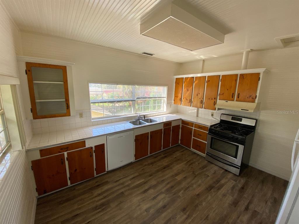 902 South Grove Street, Unit 2 Eustis, FL 32726 - Photo 7 of 11 a kitchen with stainless steel appliances kitchen island granite countertop a stove a sink and a microwave