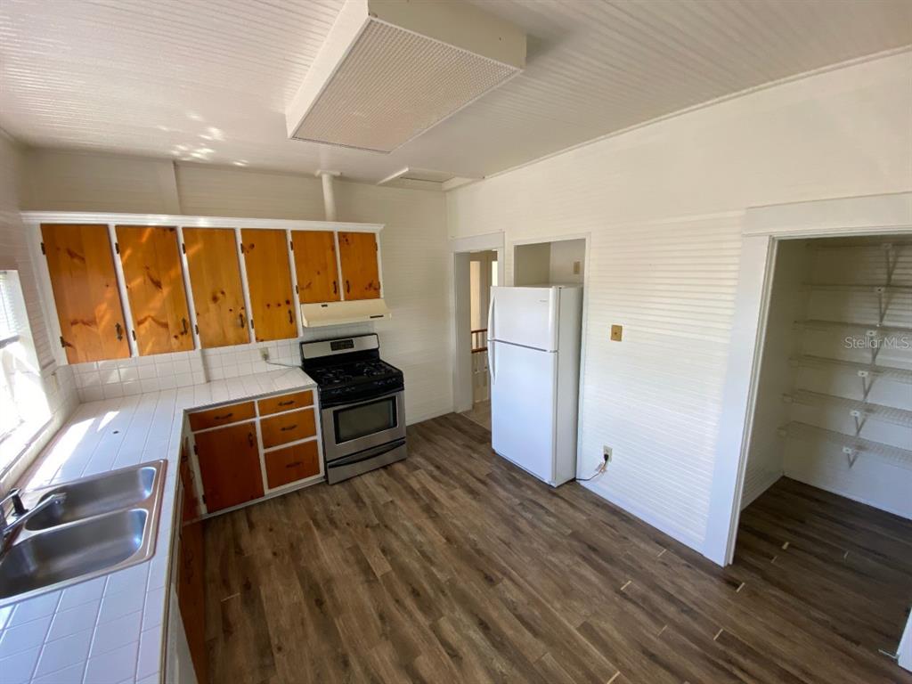 902 South Grove Street, Unit 2 Eustis, FL 32726 - Photo 8 of 11 a kitchen with wooden cabinets and a stove top oven
