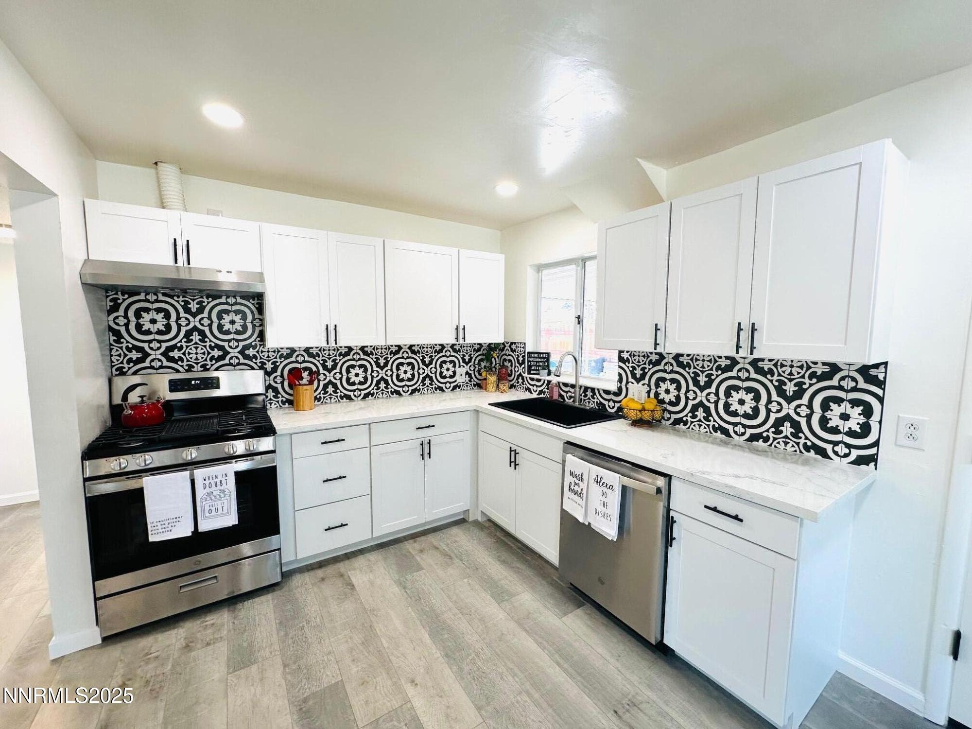 1570 Radcliffe Drive Reno, NV 89502 - Photo 2 of 11 a kitchen with stainless steel appliances white cabinets a sink and a stove