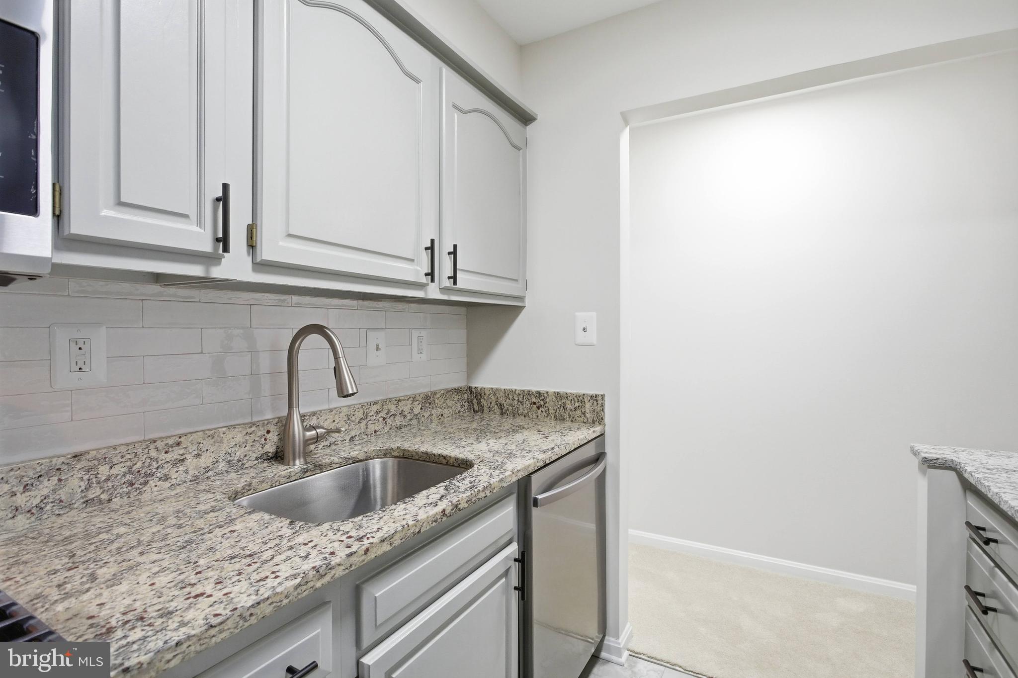 5902 Cove Landing Road, Unit 202 Burke, VA 22015 - Photo 7 of 52 a kitchen with granite countertop a sink and cabinets
