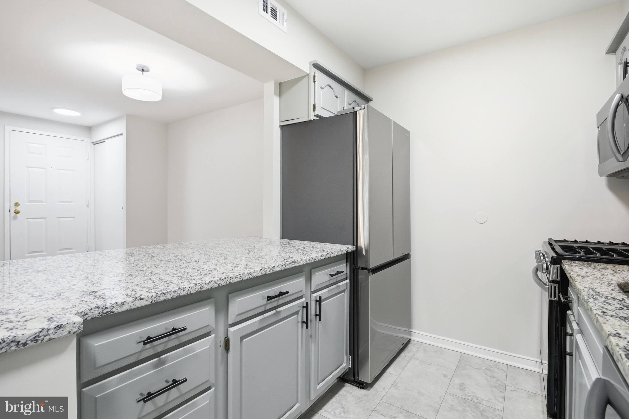5902 Cove Landing Road, Unit 202 Burke, VA 22015 - Photo 8 of 52 a kitchen with stainless steel appliances granite countertop a refrigerator and a sink