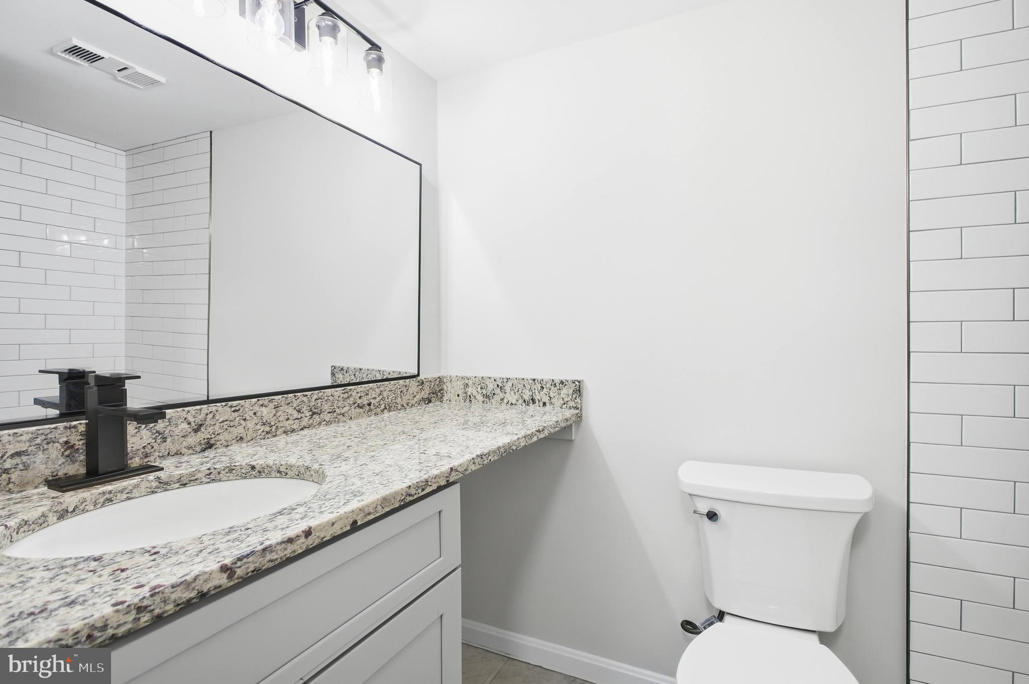 5902 Cove Landing Road, Unit 202 Burke, VA 22015 - Photo 10 of 52 a bathroom with a granite countertop sink and a toilet