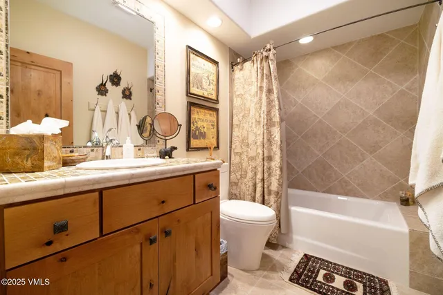 a bathroom with a double vanity sink toilet and shower
