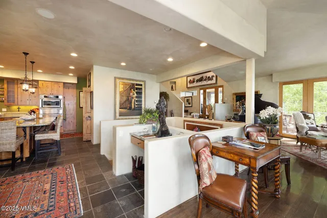 a living room with stainless steel appliances kitchen island granite countertop furniture a rug kitchen view and a fireplace