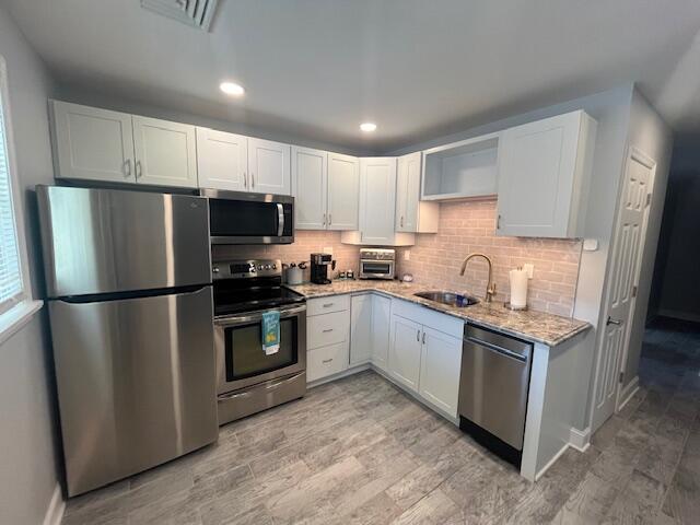 100 Broad Street, Unit E Stroudsburg, PA 18360 - Photo 3 of 25 a kitchen with stainless steel appliances granite countertop a refrigerator stove a sink and a microwave