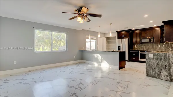 a view of kitchen with stainless steel appliances kitchen island granite countertop a refrigerator oven a sink and dishwasher