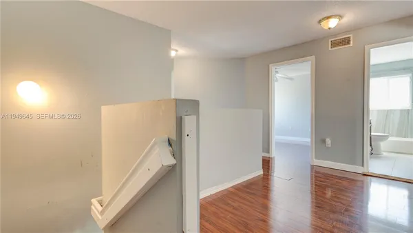 a view of a hallway with wooden floor and entryway