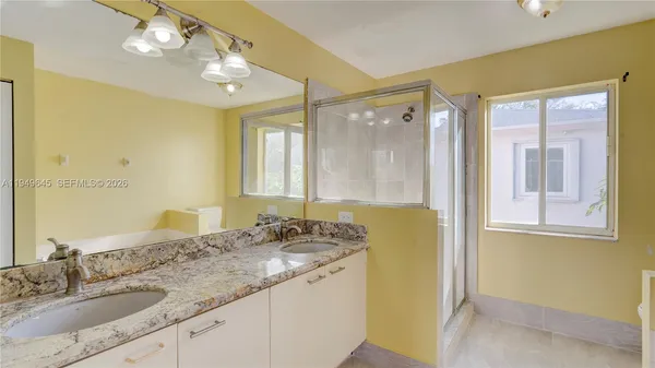 a bathroom with a granite countertop sink and a mirror