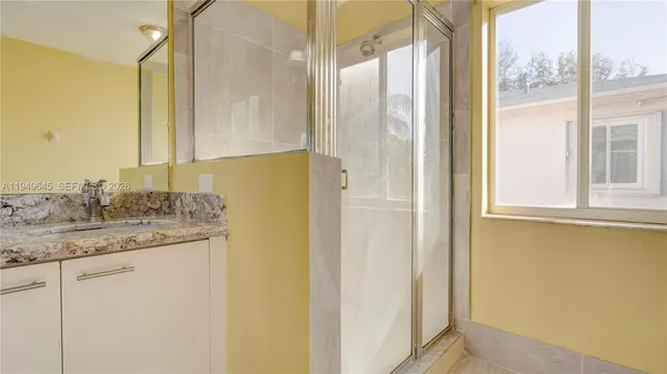a bathroom with a granite countertop sink and a mirror