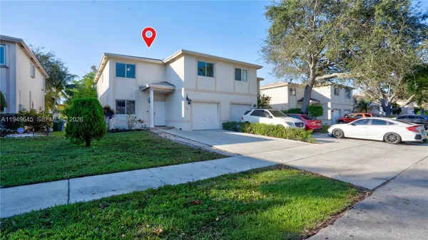 a backyard of a house with table and chairs plants and large tree