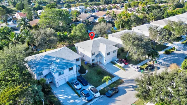 an aerial view of a house with a yard and street