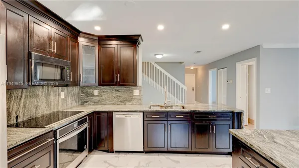 a kitchen with granite countertop a sink and a stove
