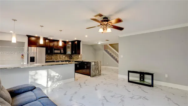 a living room with stainless steel appliances kitchen island granite countertop furniture and a kitchen view