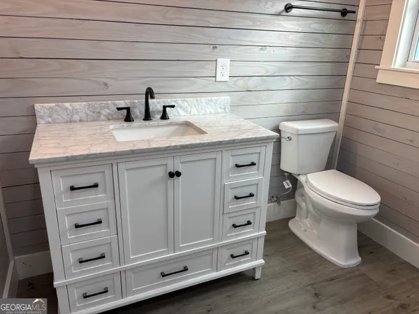 a bathroom with a granite countertop toilet and sink