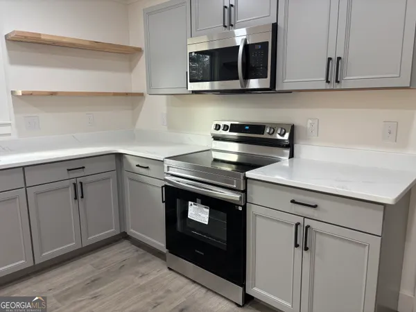 a kitchen with stainless steel appliances granite countertop a sink and a microwave