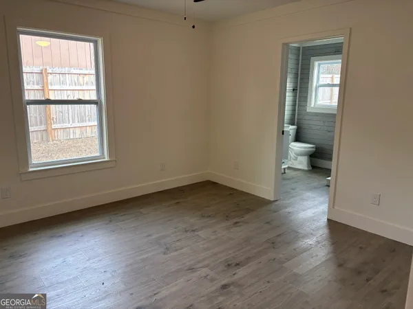 an empty room with wooden floor and a window
