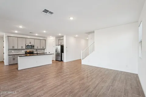 a kitchen with granite countertop a sink stainless steel appliances and white cabinets