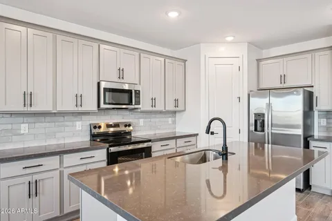 a kitchen with stainless steel appliances granite countertop a stove a microwave and a white cabinets