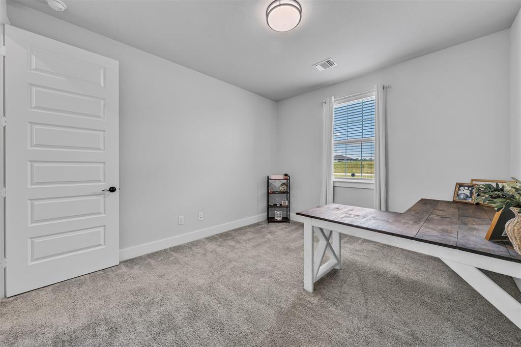 2004 Willy Dilly Road Springtown, TX 76082 - Photo 20 of 40 Room featuring carpet flooring, crisp white walls, a multi-paneled door with black hardware, and a window with blinds providing natural illumination