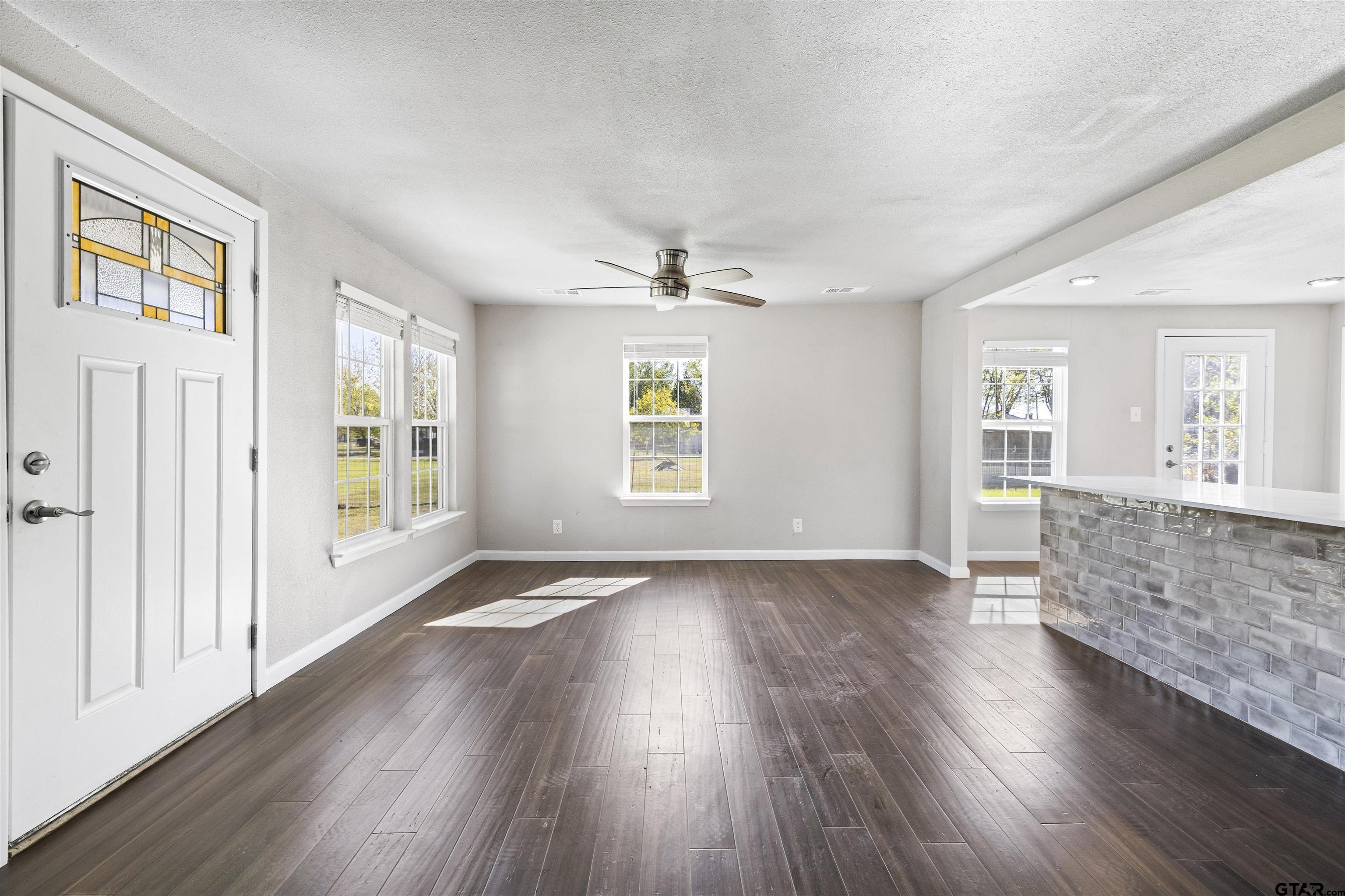 229 Orchard Street Alba, TX 75410 - Photo 4 of 16 an empty room with wooden floor and windows