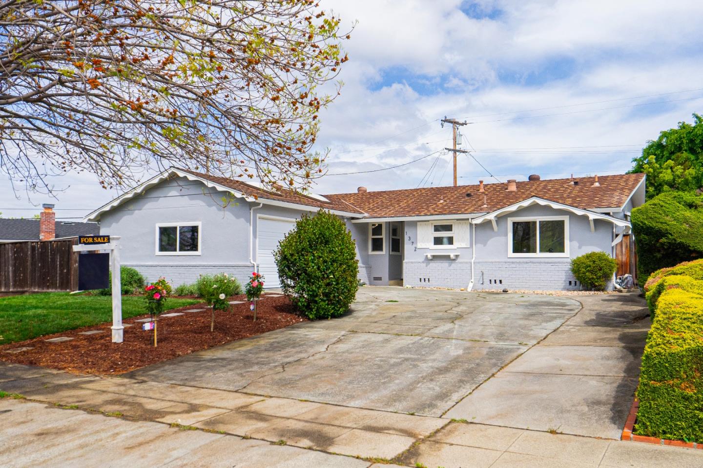 a front view of a house with a yard and potted plants