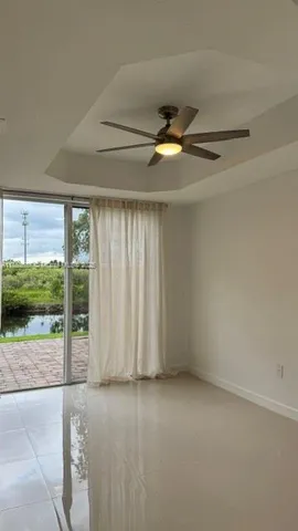 an empty room with a ceiling fan and windows