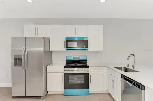 a view of a big room with wooden floor and windows