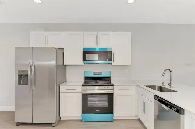 a view of a big room with wooden floor and windows