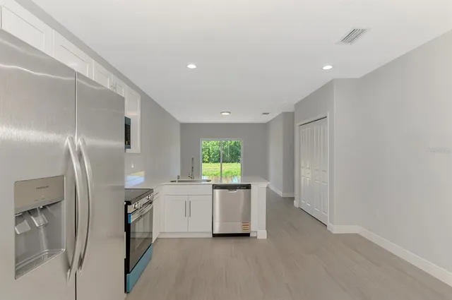 an empty room with a window and ceiling fan
