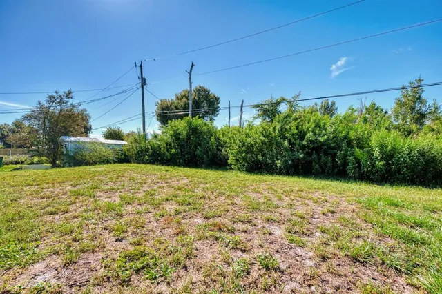 a view of an empty room with wooden floor and window