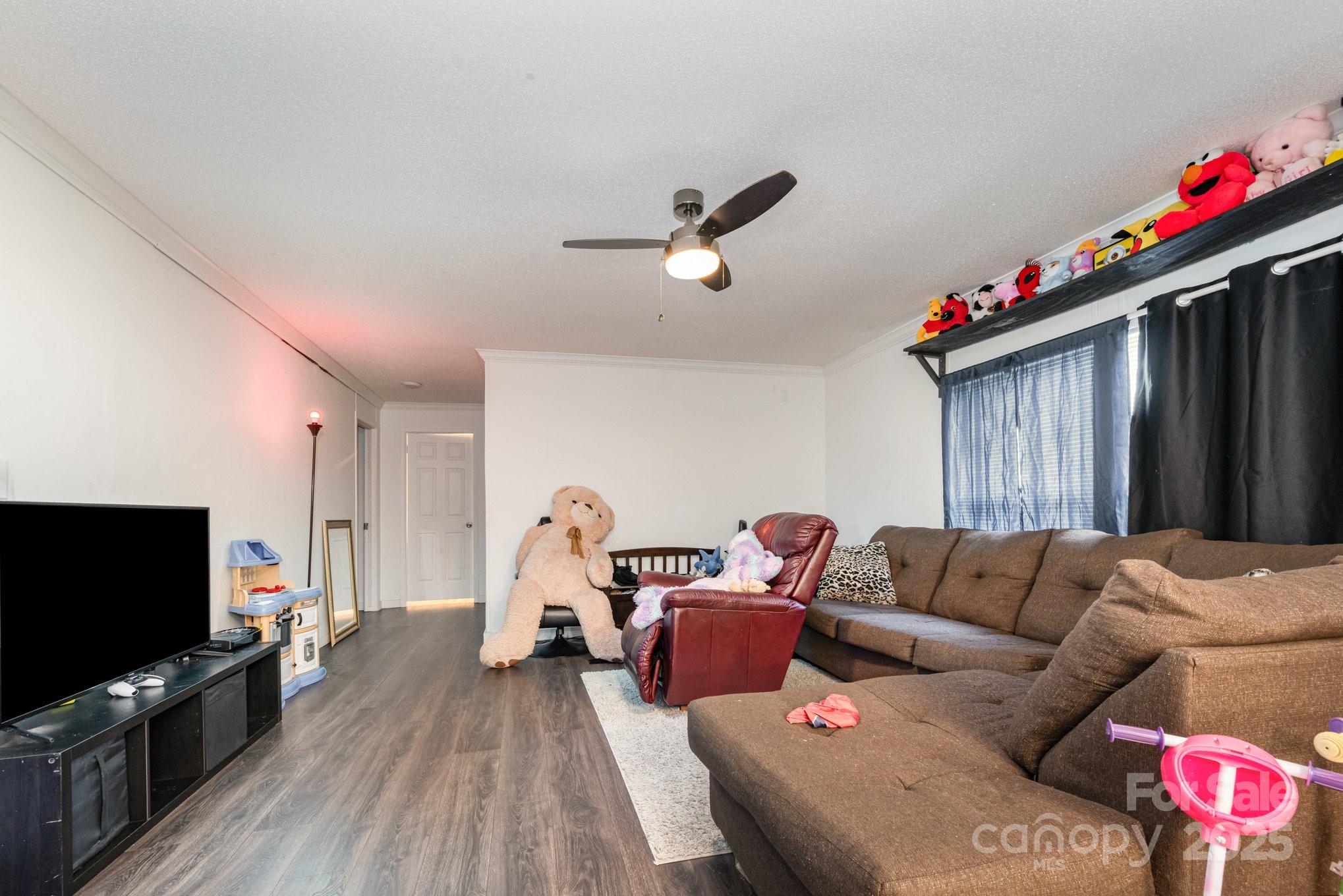 6555 McIntosh Road Stanley, NC 28164 - Photo 9 of 24 a living room with furniture a flat screen tv and kitchen view