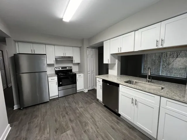 a kitchen with cabinets stainless steel appliances and a counter space