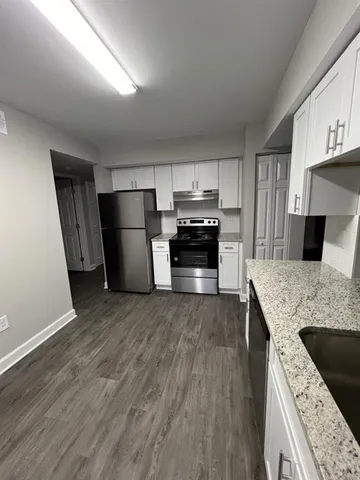 a kitchen with a sink a microwave a refrigerator and cabinets
