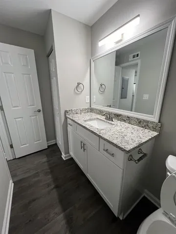a bathroom with a granite countertop sink and a mirror