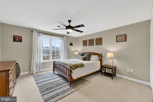 a bedroom with a bed and a ceiling fan