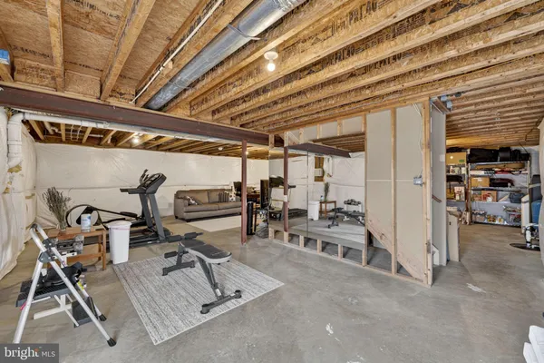 a view of stairs and an empty room with wooden floor