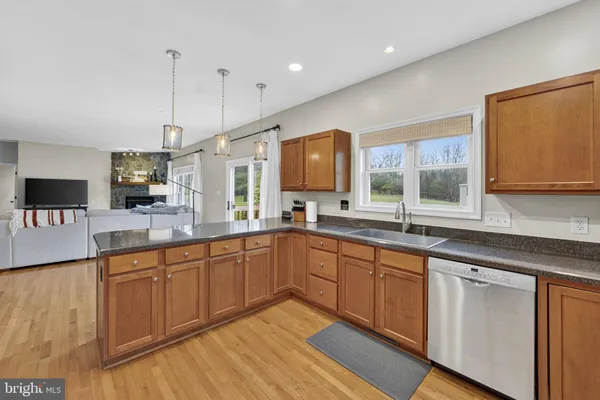 a kitchen with stainless steel appliances granite countertop a sink a stove top oven a counter space and cabinets