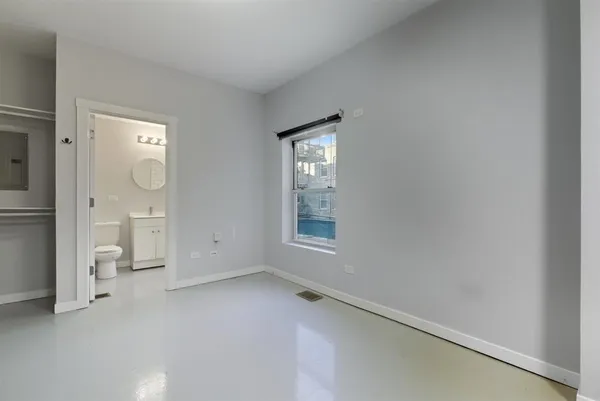 an empty room with mirror and a window