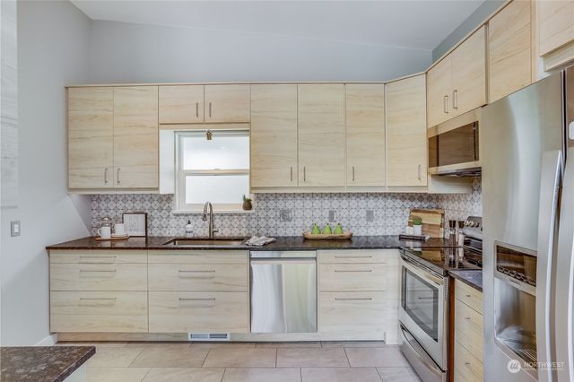 a kitchen with white cabinets stainless steel appliances and a sink