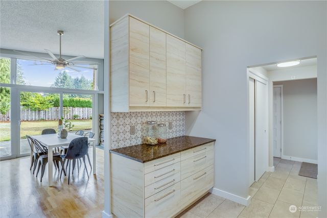 a kitchen with a stove a refrigerator and a dining table with wooden floor