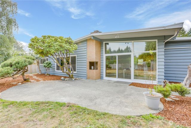 a view of a house with backyard and sitting area