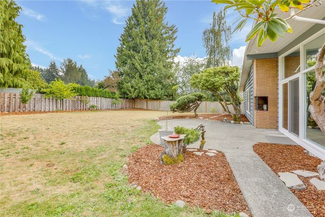 a backyard of a house with table and chairs