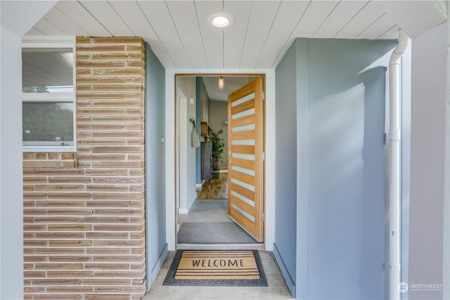 a view of a hallway with wooden floor and a window