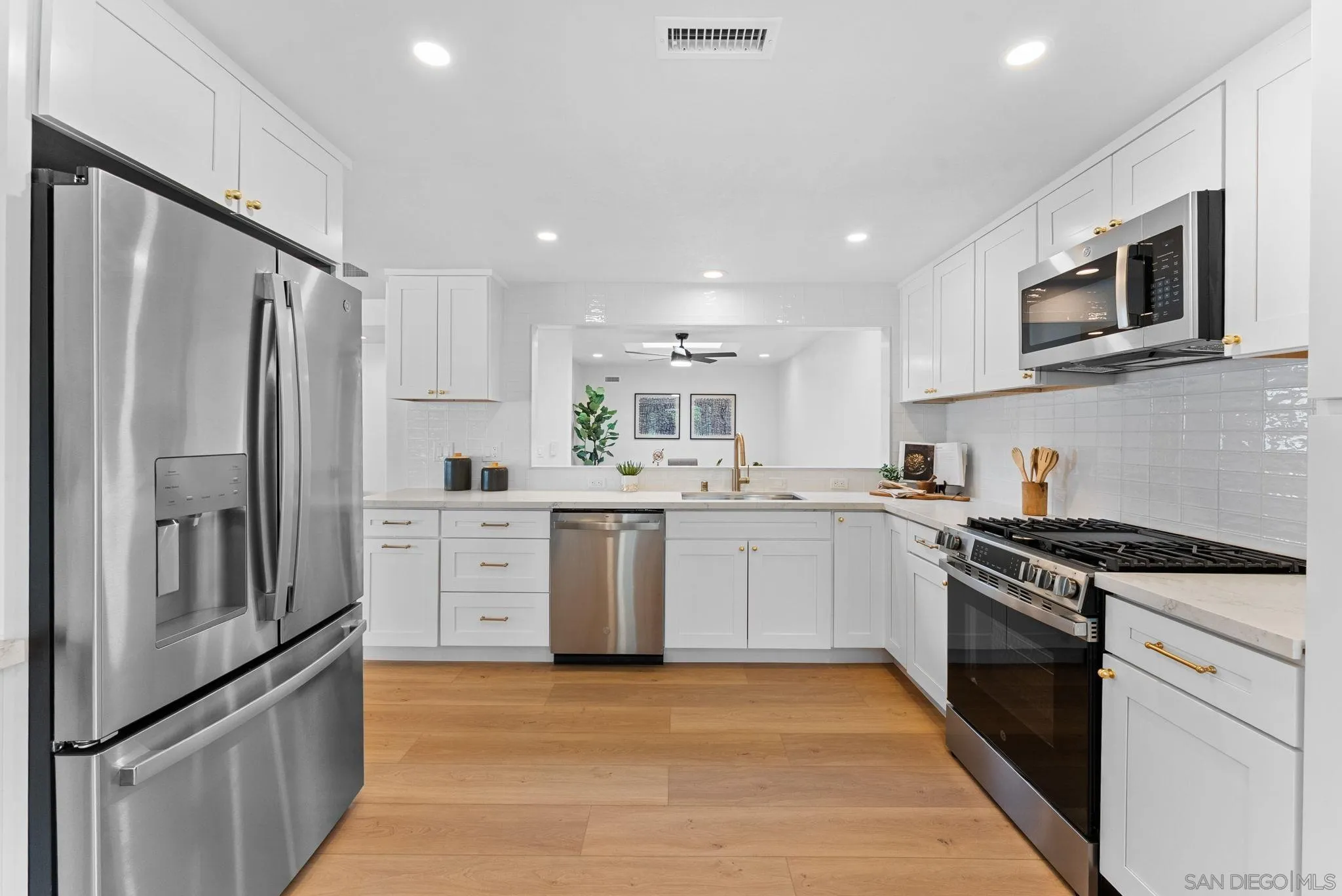 4695 Adra Way Oceanside, CA 92056 - Photo 13 of 29 a kitchen with white cabinets and stainless steel appliances