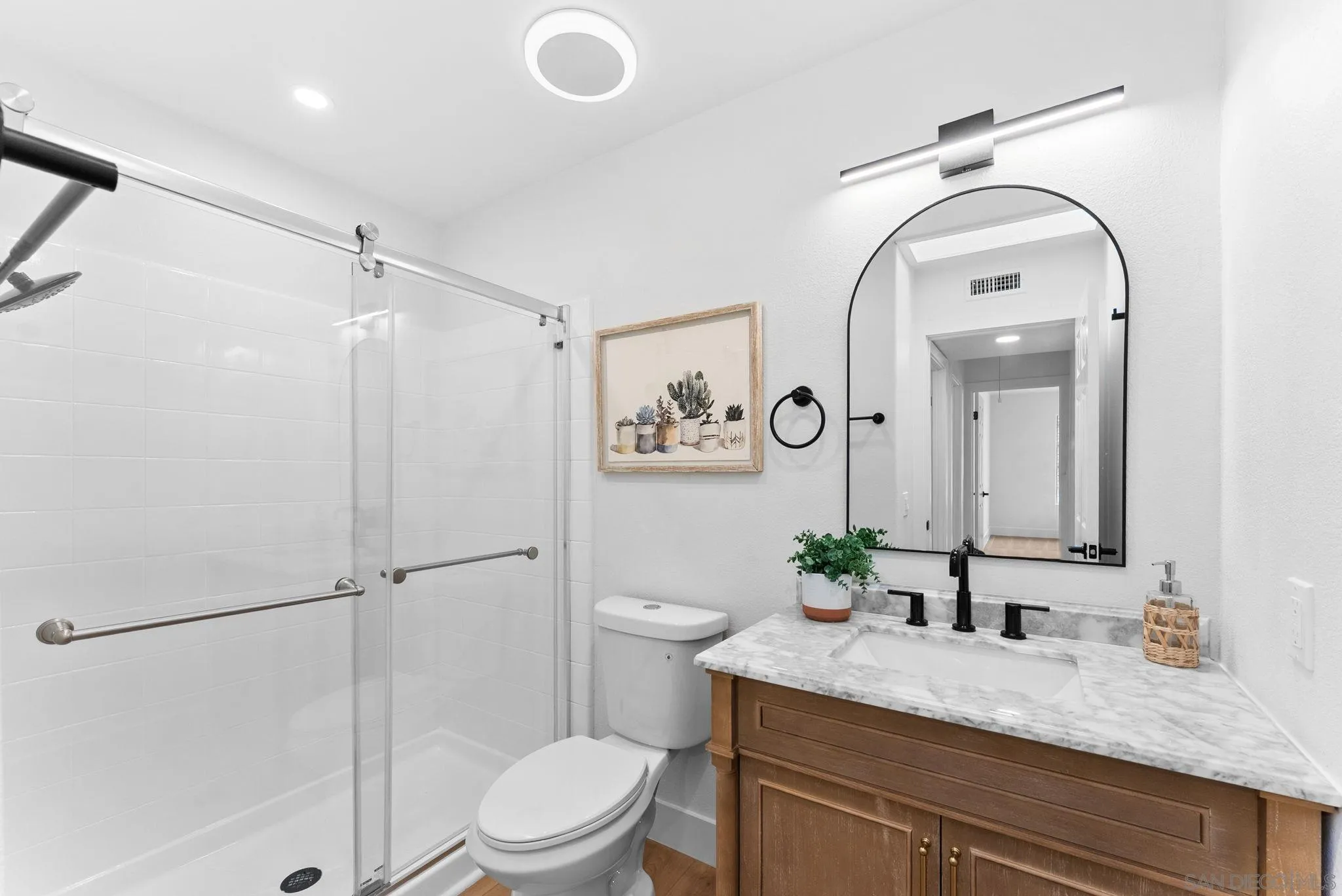 4695 Adra Way Oceanside, CA 92056 - Photo 25 of 29 a bathroom with a granite countertop sink mirror vanity and toilet