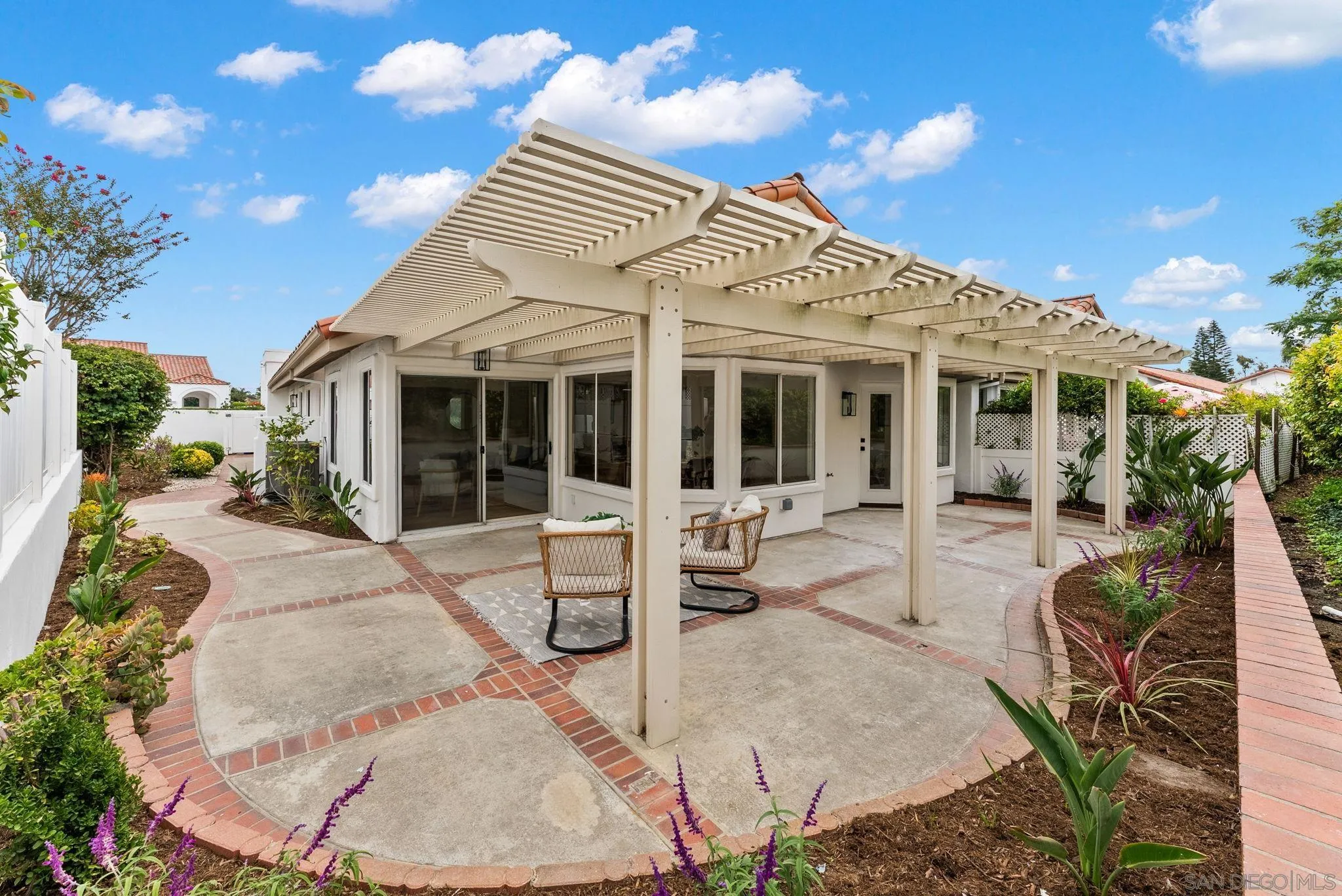 4695 Adra Way Oceanside, CA 92056 - Photo 5 of 29 a view of a white building with couches potted plants and a table