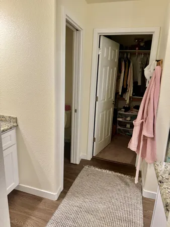 a view of a hallway with wooden floor and closet