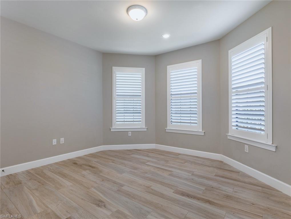 19953 Beverly Park Road Estero, FL 33928 - Photo 17 of 35 a view of an empty room with wooden floor and a window