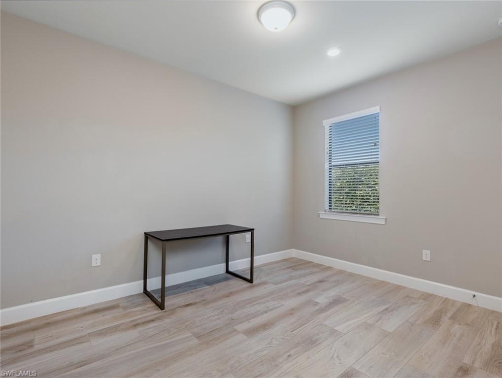 19953 Beverly Park Road Estero, FL 33928 - Photo 19 of 35 a view of an empty room with wooden floor and a window